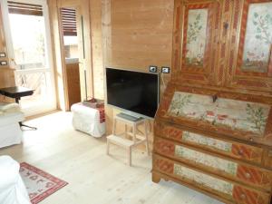 a living room with a television and a large dresser at Villa 5 Torri in Cortina dʼAmpezzo