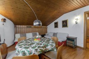 una sala da pranzo con tavolo e sedie e una sala con piano cottura di Spazioso appartamento centrale con wi-fi a Cortina dʼAmpezzo