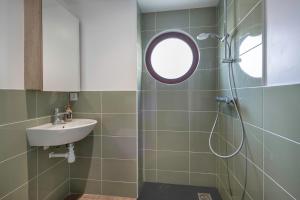 a bathroom with a sink and a shower with a mirror at Vue mer, 30m de la plage, 5 adultes & 1 enfant in Préfailles