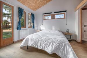 a white bedroom with a bed and a window at Maison avec dépendance pour 11 à 800m de la mer in La Plaine-sur-Mer
