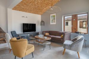 a living room with a couch and chairs and a tv at Maison avec dépendance pour 11 à 800m de la mer in La Plaine-sur-Mer