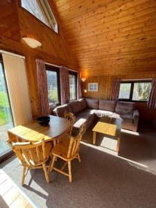 ein Wohnzimmer mit Sofa und Tisch in der Unterkunft 3 Bedroom Lodge Lanteglos 21 in Lanteglos