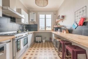 a kitchen with a counter and stools in it at BLEU TOUCAN - 700m plage - Parking in Saint-Nazaire +12 photos