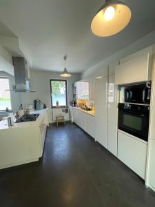 a kitchen with white cabinets and a stove top oven at Zarlar House in Geraardsbergen