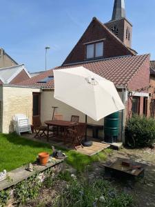 a patio with a table and a white umbrella at Zarlar House in Geraardsbergen +46 photos