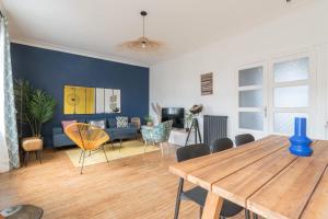 a living room with a wooden table and chairs at BLEU TOUCAN - 700m plage - Parking in Saint-Nazaire