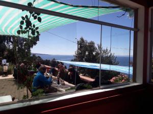 a group of people sitting at a table looking out a window at LA MANSION DEL SOL LODGE Taquile island in Isla Taquili +9 photos