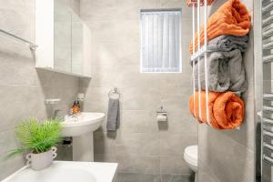 ein Bad mit einem Waschbecken, einem WC und Handtüchern in der Unterkunft Brierfield Cottage in Brierfield