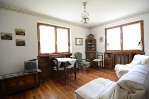 un salon avec un canapé et une télévision dans l'établissement Cà Mughi Studio, à Zuel