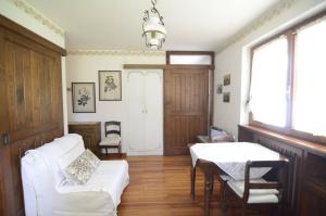 un salon avec un canapé blanc et une table dans l'établissement Cà Mughi Studio, à Zuel