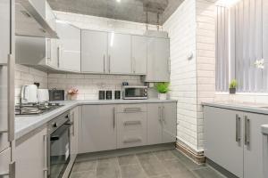 eine weiße Küche mit weißen Schränken und Geräten in der Unterkunft Brierfield Cottage in Brierfield + 8 Fotos