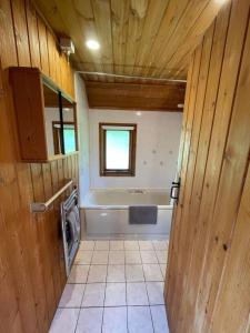 ein Badezimmer mit einer Badewanne, einem Waschbecken und einer Waschmaschine in der Unterkunft 3 Bedroom Lodge Lanteglos 21 in Lanteglos