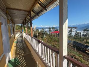 a balcony of a house with a view of the mountains at The Nature Homestay in Pedong