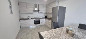 a small kitchen with a table and a refrigerator at EremAre casa vacanza in Marina di Massa