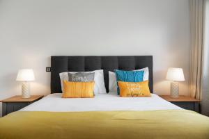 a bedroom with a large bed with colorful pillows at Amparo II by An Island Apart in Funchal