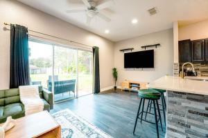 a kitchen and living room with a large window at Full House HotTub Mins to UCF in Bithlo