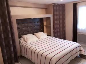 a bedroom with a bed with a black and white comforter at Gîte du Marronnier in Magné