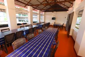 a dining room with blue tables and chairs at ILLIKKALAM Lakeside Cottages Kumarakom Kerala in Kumarakom
