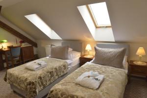 two beds in a room with skylights at Kaštieľ Lodomeria Manor House in Lučenec +4 photos