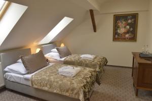 a hotel room with two beds and a desk at Kaštieľ Lodomeria Manor House in Lučenec