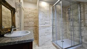 a bathroom with a glass shower and a sink at Kaštieľ Lodomeria Manor House in Lučenec