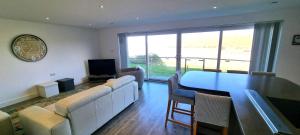 ein Wohnzimmer mit Tisch und Stühlen und einem Fernseher in der Unterkunft Ocean View in Perranporth