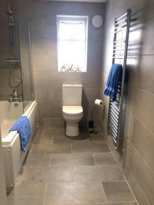 ein Bad mit einem WC, einer Badewanne und einem Fenster in der Unterkunft Ocean View in Perranporth