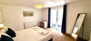 Zimmer mit einem Bett, einem Spiegel und einem Fenster in der Unterkunft Ocean View in Perranporth