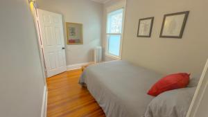 アルバニーにあるThe Rustic Home Albany NY - 3 Bedroom Private Second Floor Apartmentのベッドルーム1室(赤い枕付きのベッド1台付)