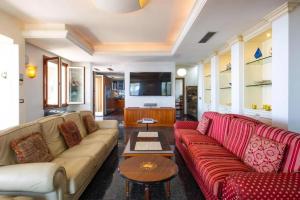 a living room with red couches and a tv at Villa Paradise-Sleeps 20-Pool-Sea Views-pets in Ospedaletti
