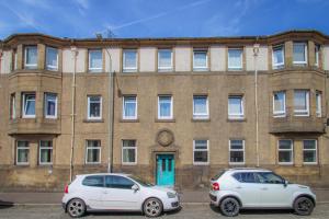 two cars parked in front of a brick building at 3-Bed Apartment - Near Clyde Shipyard - 25 min Glasgow Airport in Greenock