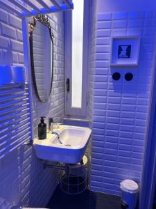 a blue bathroom with a sink and a mirror at Al Sale in Cagliari