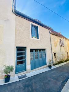 a building with blue doors on a street at La Petite Maison du Moulin in Salviac