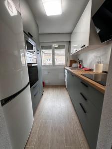 a kitchen with white appliances and a wooden floor at Duplex De los Reyes Católicos con parking incluido in Burgos