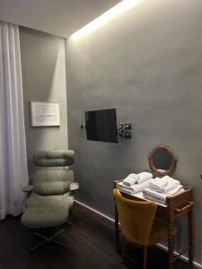 a room with a table and a chair and a tv at Al Sale in Cagliari