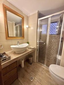 a bathroom with a sink and a shower at Dion and Eva's OldTown Apartment in Corfu Town