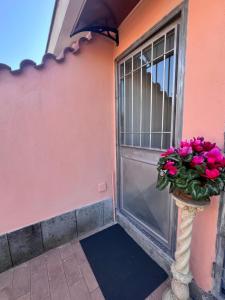 a door with a vase of pink flowers on it at ROSSI SUITE Fco in Isola Sacra