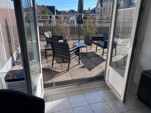 a screened in porch with chairs and a table at Appartement centre ville et terrasse in Brive-la-Gaillarde