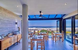 a kitchen and dining room with a view of the ocean at Sawubona Guesthouse in Beach View