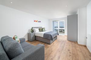 a living room with a bed and a couch at Exquisite 2bed Apt with Parking Near 02 Arena in London