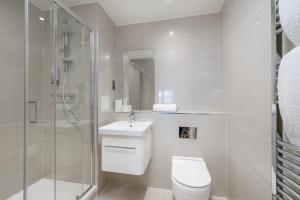 a bathroom with a toilet and a shower and a sink at Exquisite 2bed Apt with Parking Near 02 Arena in London +28 photos