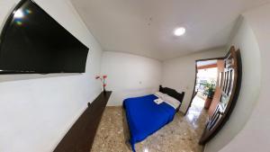 a room with a tv on the wall and a couch at Hotel La Casona Ituango in Ituango