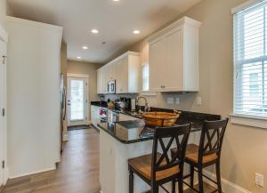 una cucina con armadi bianchi e bancone con sedie di 406B The North End House a Virginia Beach