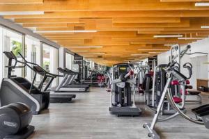 un gimnasio con una fila de pisadas y máquinas en 2BR Apartment with Beach Club, en Cancún