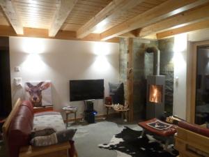 a living room with a couch and a tv at Chalet Mont Noble, Les Masses, 4 Vallées Verbier in Hérémence