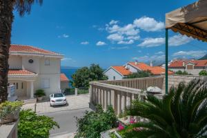 a house with a car parked in a driveway at Vera i Ćiro Novak 2, sea view and free parking in Brela