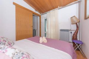 a bedroom with a bed with two slippers on it at Vera i Ćiro Novak 2, sea view and free parking in Brela