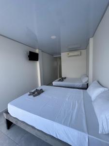 a bedroom with two beds and a tv on the wall at Palmarena in Puerto Viejo