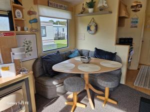 a living room with a table and a couch at 3-Bed Caravan - Sleeps 8 - Pool Onsite - PetsOK in Skegness
