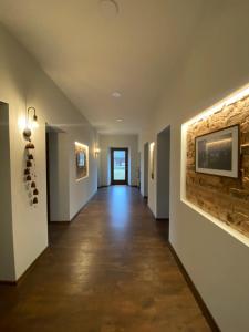 a hallway with white walls and a tile floor and a painting at Laumės dvaras in Kruopinė